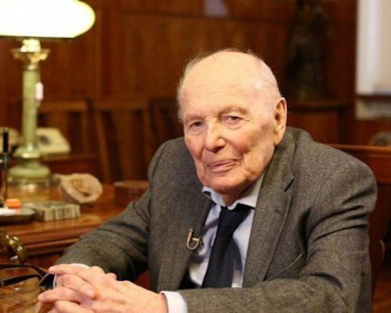 Борис Патон в костюмі з краваткою сидить за столом в кабінеті