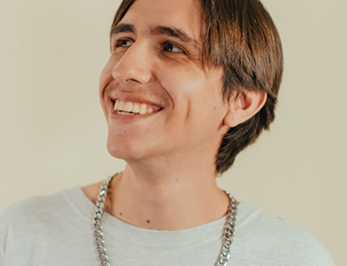 Smiling young man wearing a white t-shirt and necklace