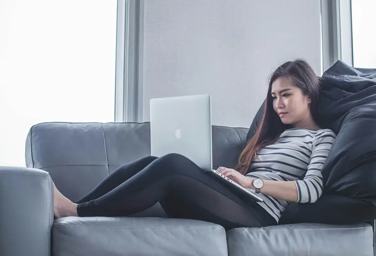 Young woman on the sofa with a laptop