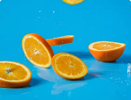Freshly sliced oranges displayed on a bright blue background.